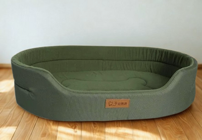 Grünes ovales Hundebett mit erhöhtem Rand aus Stoff, gepolsterter Liegefläche und atmungsaktivem Material – bequemes Komfortbett für kleine und mittelgroße Hunde.